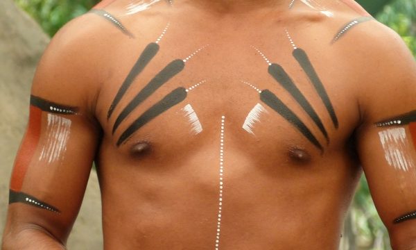 puntoycoma-tattoo-studio-tatuaje-tribal Se ve el pecho de un hombre como si estuviera en la selva. Lleva tatuajes tribales
