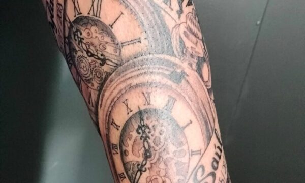 puntoycoma-tattoo-studio-tatuaje-relojes-antiguos tatuaje de dos relojes antiguos donde se ve el nombre, la fecha y la hora del nacimiento de los nietos de nuestro cliente